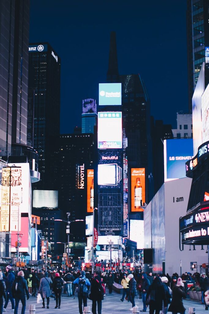 Bustling night scene in Times Square, New York City, illuminated with vibrant advertisements.