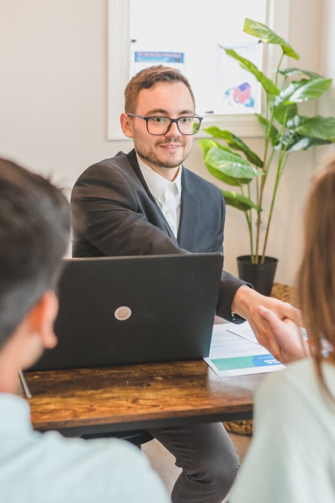 A mortgage broker meeting clients in an office, discussing agreements and loans.
